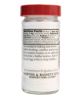 Glass jar with red lid and white label displaying nutrition facts and product details.