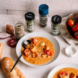 Tomato soup with garnishes and spices on a table