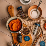 Spice ingredients and products on a wooden board with a towel underneath