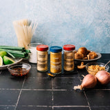 Spices and ingredients on a kitchen counter with a blue textured wall background