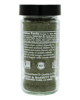 Glass jar of green spice with label 