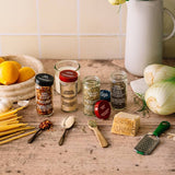 Spices and ingredients on a wooden surface with a kitchen background