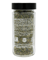 Jar of dried herbs with a black lid on a white background
