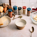 Spices and ingredients on a kitchen counter with a focus on seasoning.
