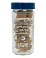 Glass jar of whole nutmeg with blue lid, labeled with nutritional info and certifications, including non-GMO and gluten-free.