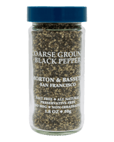 A clear glass jar of Morton & Bassett Coarse Ground Black Pepper with a blue screw cap, shown against a solid black background.