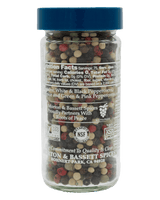 A clear plastic spice jar filled with mixed peppercorns under a blue lid, shown against a solid black background. The front label reads Morton & Bassett Spices.