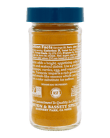 A bottle of Morton & Bassett Spices turmeric paste with a blue cap, showing the back label with text and certification logos 