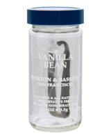 A clear glass jar with a dark blue screw-top lid containing a single vanilla bean, labeled 'VANILLA BEAN MORTON & BASSETI SAN FRANCISCO' 
