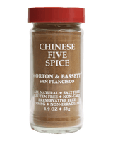 A jar of Morton & Bassett Chinese Five Spice on a solid black background. The clear glass jar shows the brownish-brown spice powder inside, topped with a red screw-on lid, and labeled with white text.
