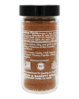 A clear plastic spice jar filled with brown ground seasoning, topped with a black lid, shown against a solid black background. The back label reads 'Bassett Spices' and includes NSF and USDA Organic certification logos.
