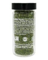 A clear plastic jar of Morton & Bassett Spice Company seasoned chopped parsley, filled with green herbs and topped with a black lid