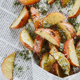 Sliced potatoes with herbs on a newspaper background