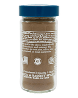 A clear plastic spice jar filled with brown ground spice, featuring a blue screw-top lid and a white label showing nutrition facts and branding for Morton & Bassett Spices.