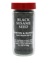 A clear glass jar filled with black sesame seeds, featuring a bright red lid and a black label with white text that reads 'BLACK SESAME SEED' and 'MORTON & BASSET SAN FRANCISCO'.